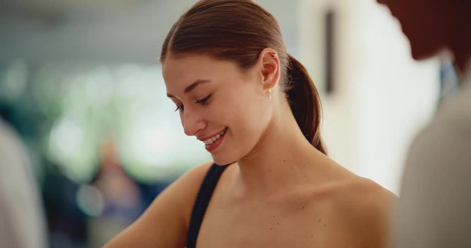 Close-up slow motion shot of a happy young woman's face as she smiles and listens