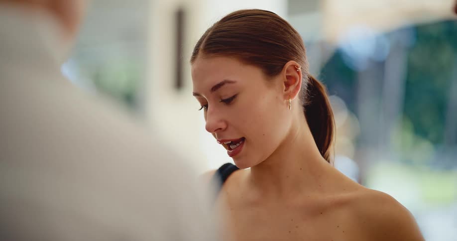 Slow motion close-up of a smiling young woman engaged in a friendly conversation
