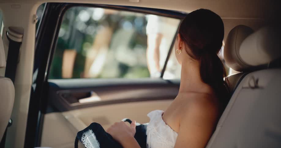 A woman in a white dress gets out of a car in slow motion, arriving for her sunny vacation