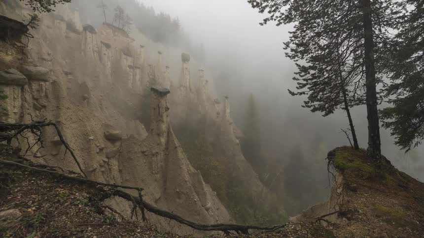 A moody timelapse captures mysterious fog rolling through a valley of unique hoodoo rock formations