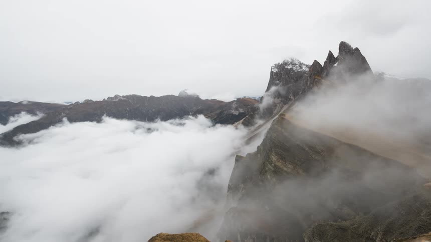 A stunning time-lapse shows a sea of clouds moving through the jagged peaks of Seceda mountain in the Italian Dolomites