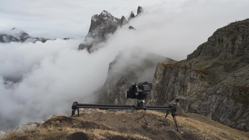Behind the scenes of a videographer filming a dramatic time-lapse of clouds moving through the Seceda mountain range in the Dolomites, Italy