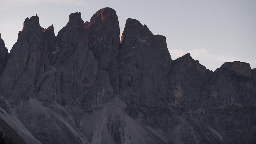 A breathtaking timelapse shows the sun rising over the jagged peaks of a majestic mountain range