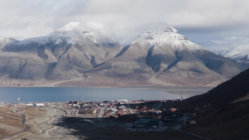 A time-lapse of clouds and shadows moving across the remote arctic town of Longyearbyen in Svalbard, nestled at the base of snow-capped mountains
