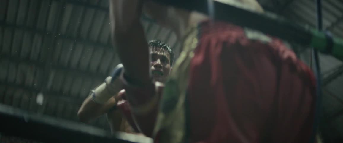 Two muscular athletes trade powerful punches in a gritty boxing ring during an intense Muay Thai fight, captured in dramatic slow motion