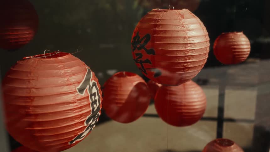 Atmospheric slow-motion shot of red Japanese 'matsuri' festival lanterns swaying gently
