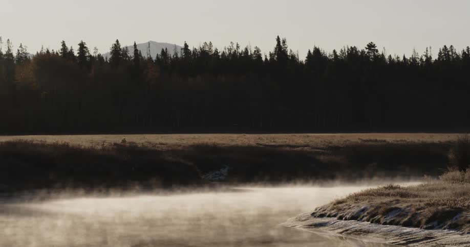 Mists rise off a river in the morning