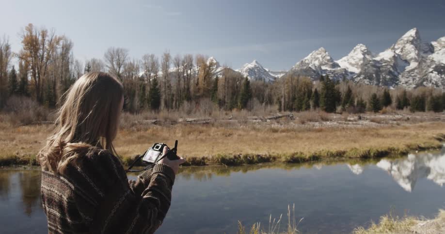 A woman photographer taking a picture of mountains