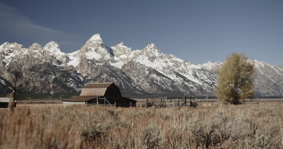 The mountains behind this  small house are covered with ice