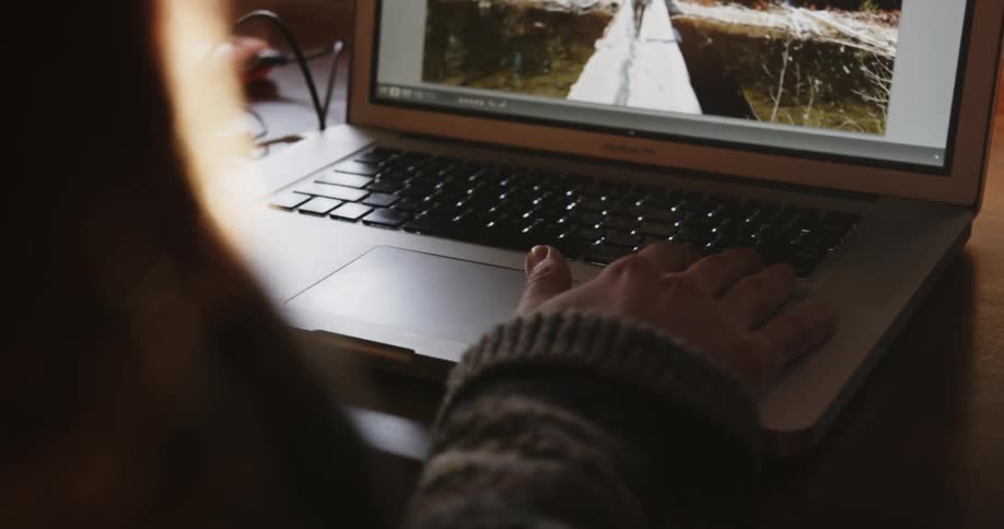 A person scrolls through photographs on a laptop