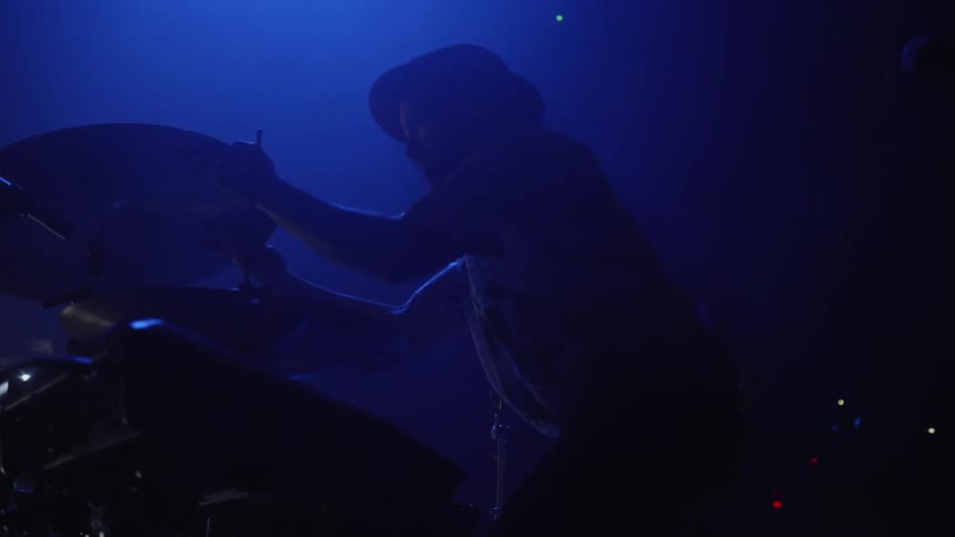 A man puts a cymbal on a drum kit