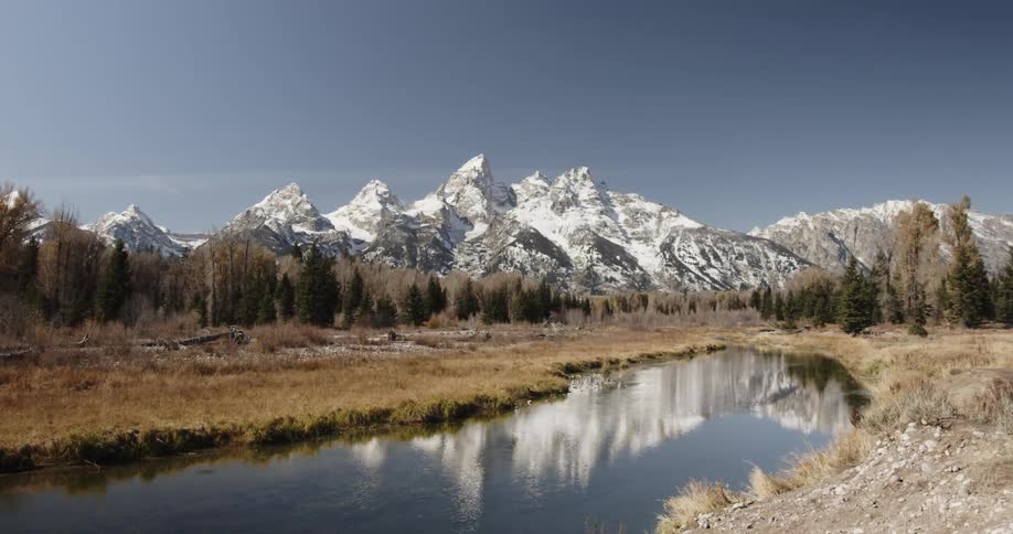 Snowy mountains stand behind a rippling lake