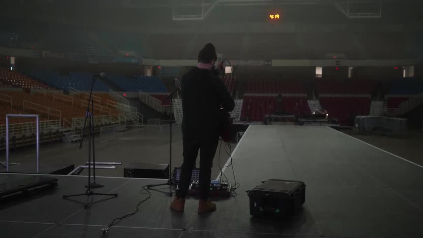 A man starts to set up the stage for a musical performance