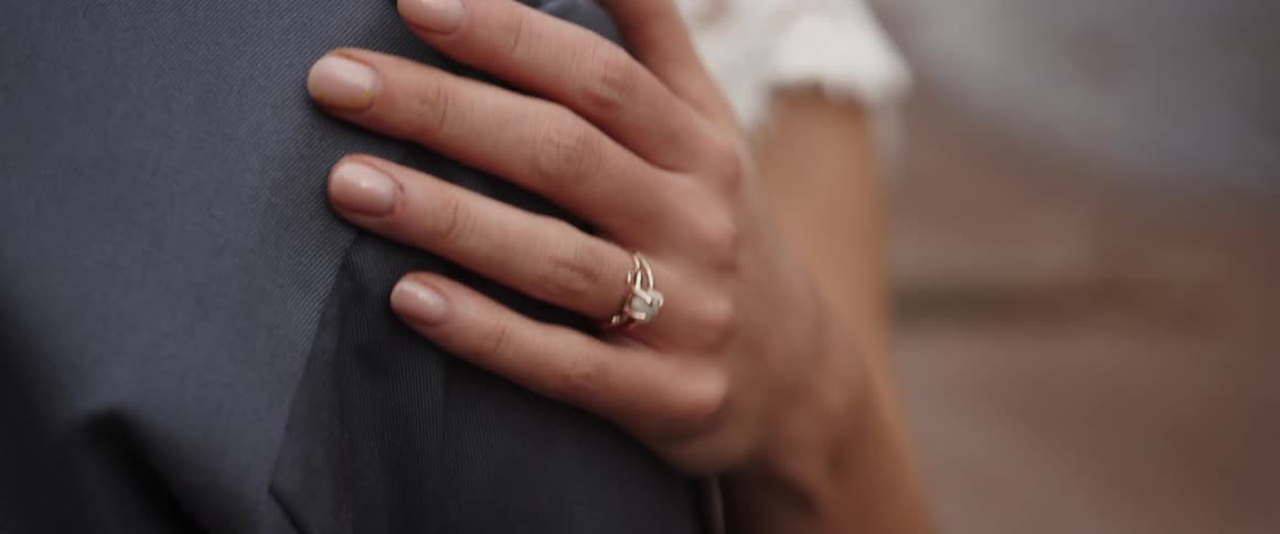 A woman runs her hand along a man's arm