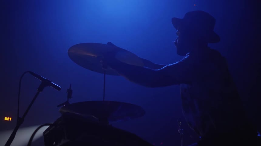 Man puts a cymbal on a drum set
