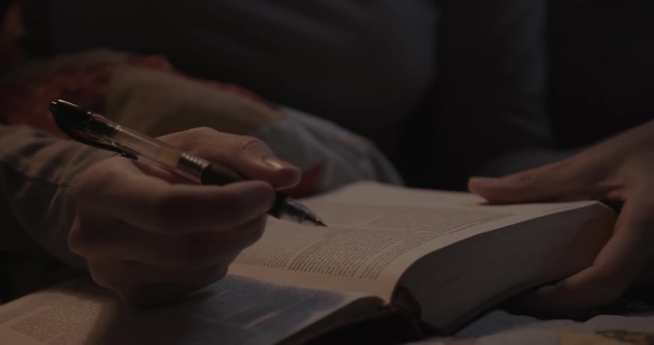 A person underlines scripture in a bible