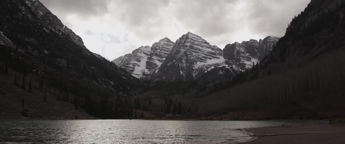A lake at the base of mountains on a cloudy day
