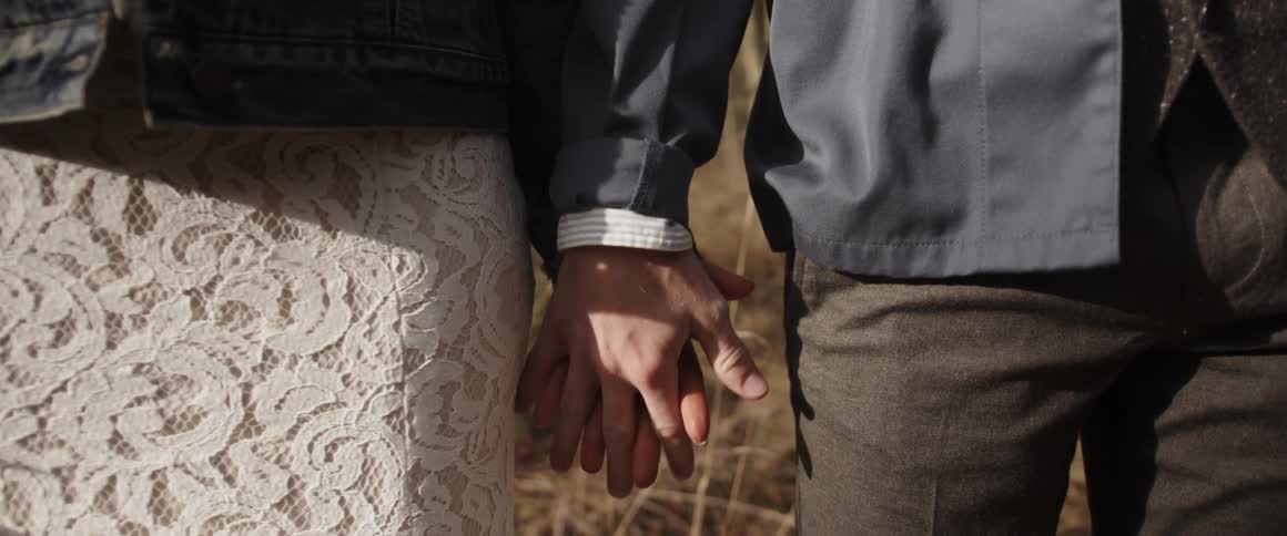 A man and woman hold hands
