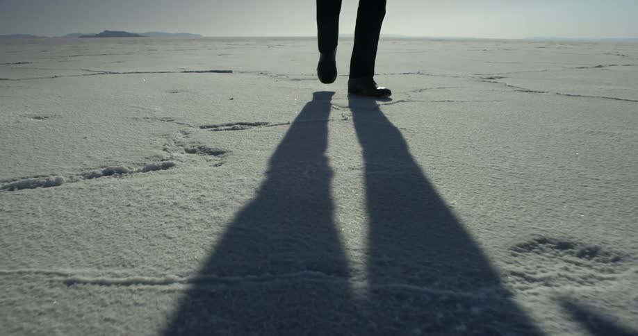 Person walks over sandy landscape on a sunny day