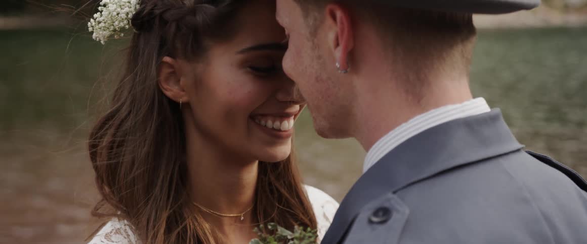 A man and women touch heads and smile