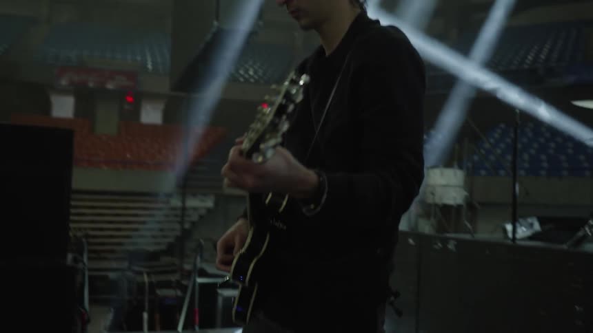 Man playing guitar in an empty auditorium