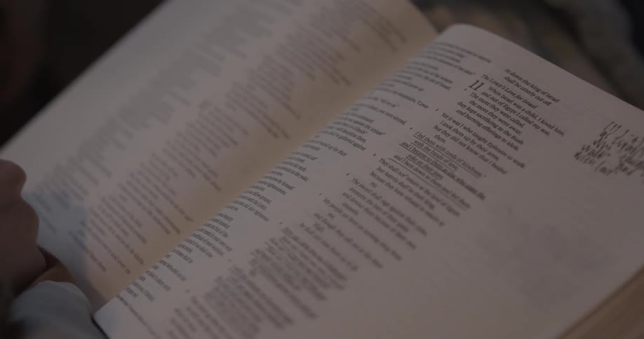 Hand resting near an open bible