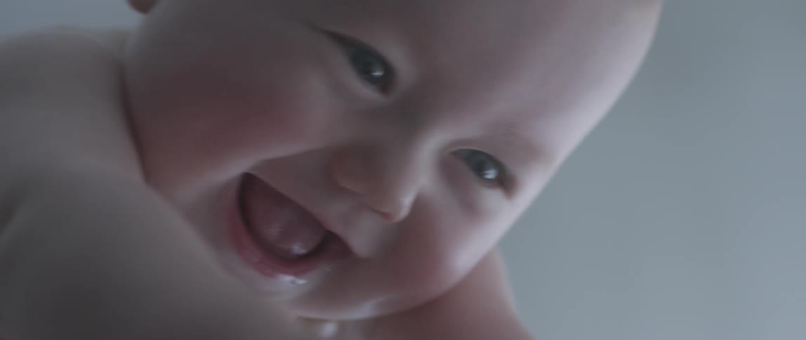 A woman holds up a smiling infant