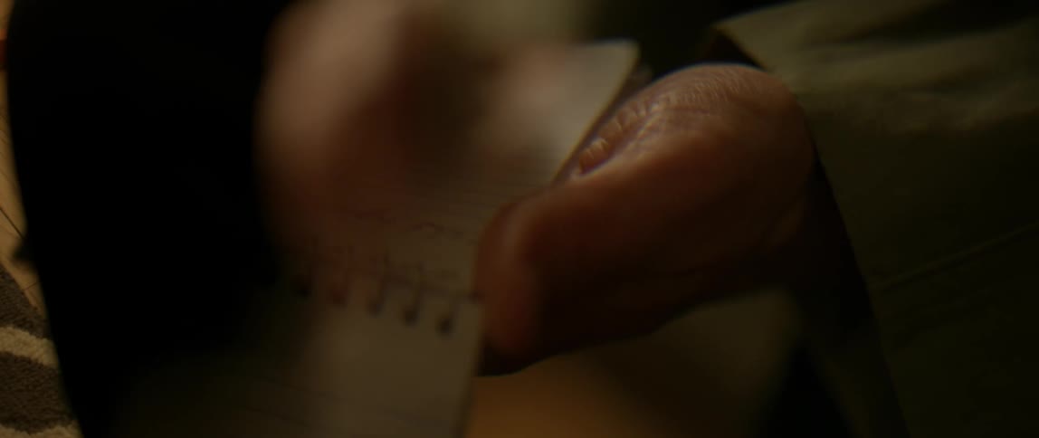 Person writes something down on a notepad with a pen