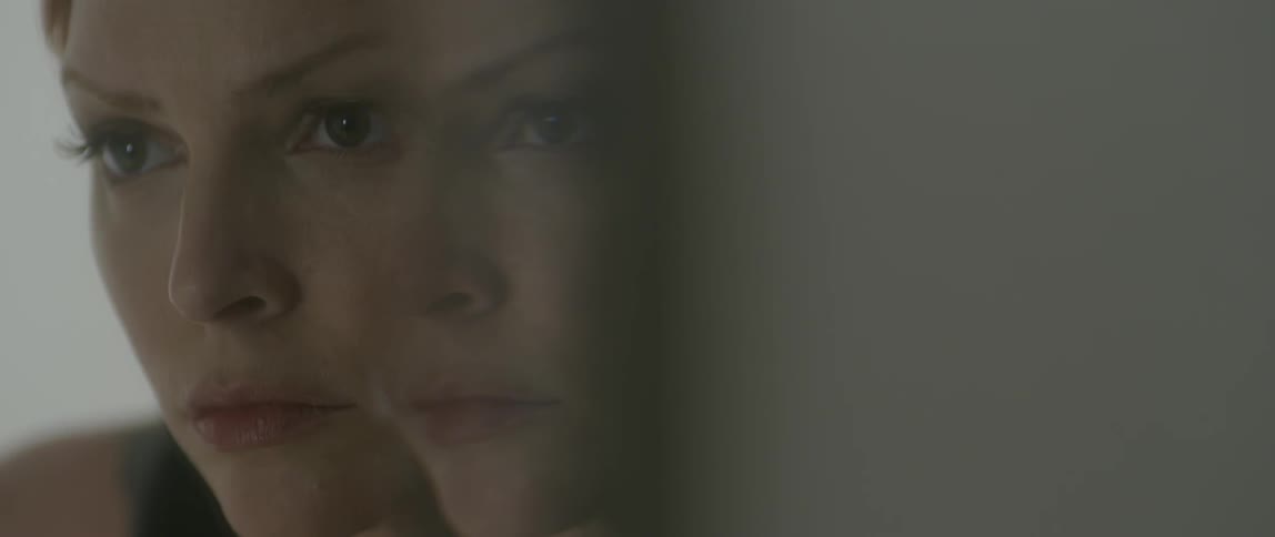 A woman is reflected twice on glass
