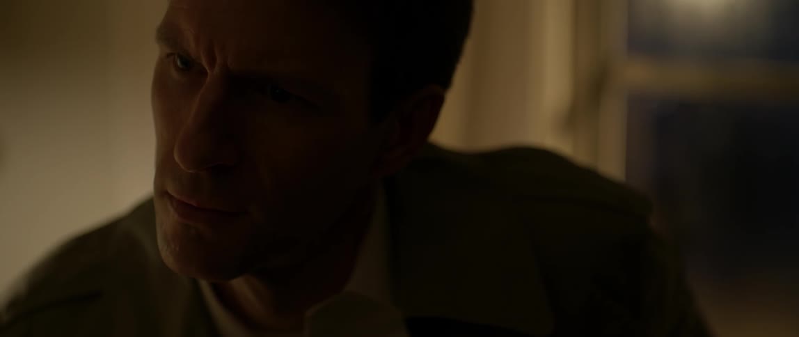 A man looks concerned while sitting indoors