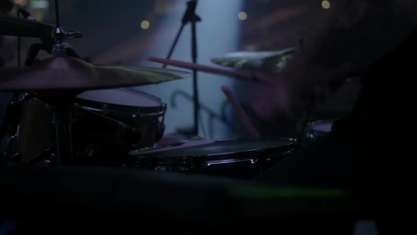 A drummer plays the drums on stage