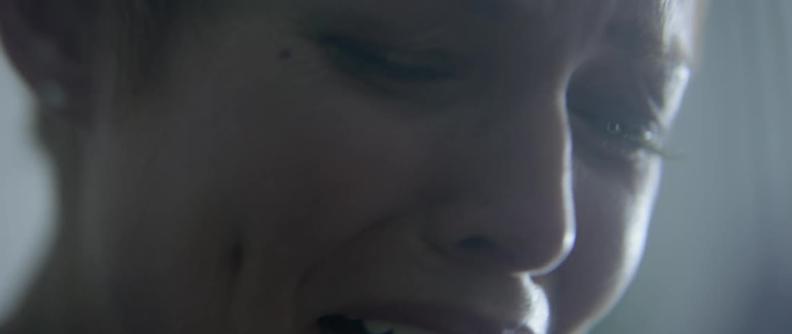 A woman is sobbing looking down