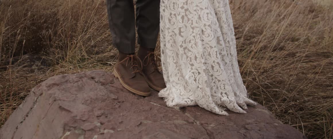 Man and woman stand on a rock outside