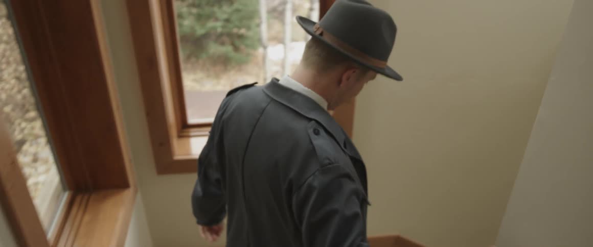 A man walks down the stairs of his home