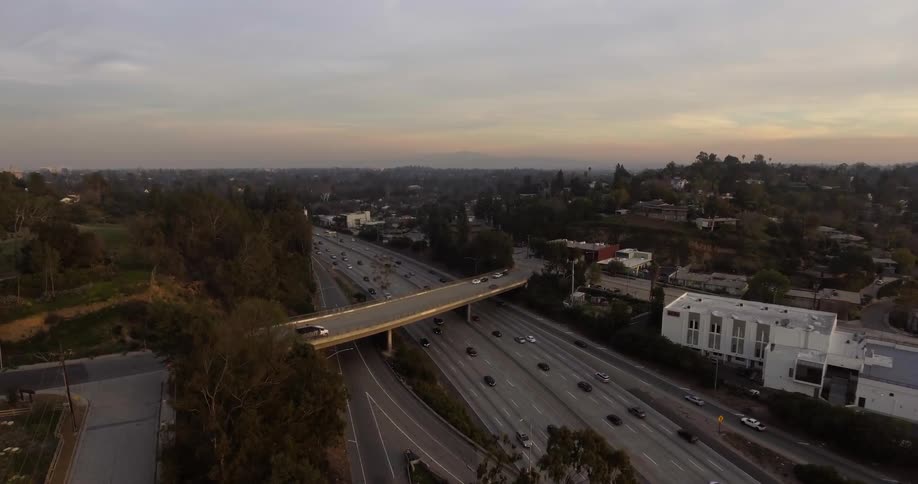 A highway with an overpass has many cars traveling
