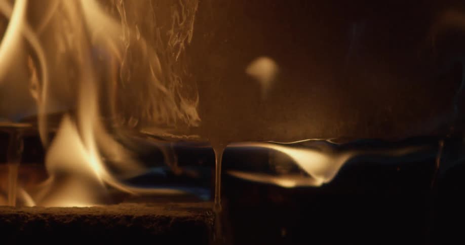 A fire rages under a pot