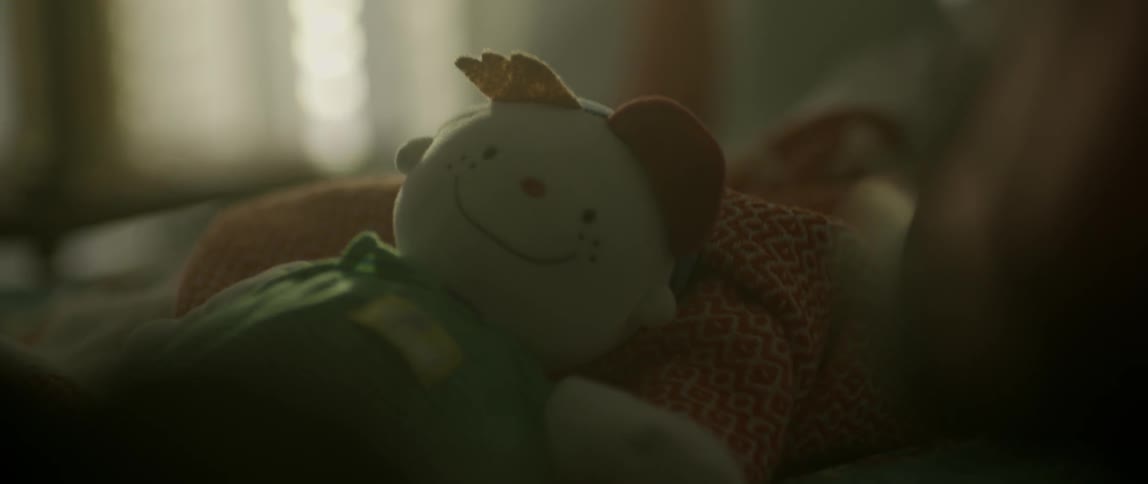 A doll lays on a bed