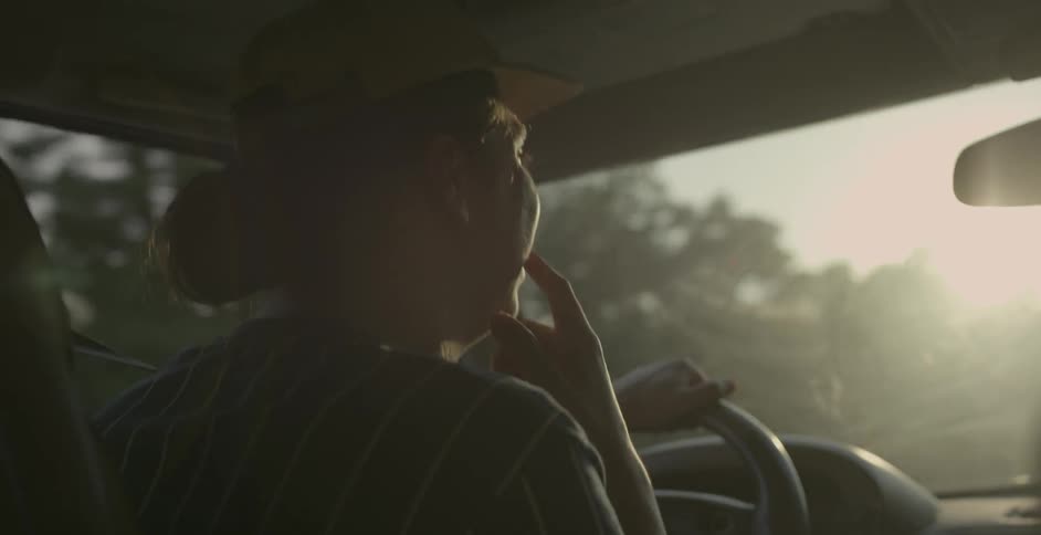 A man drives a car on a sunny day