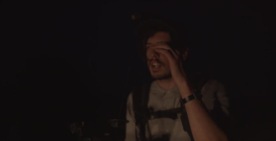 A man is sitting down in the dark