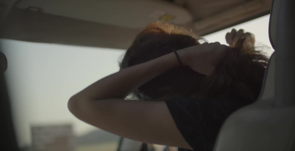 Woman sitting in a vehicle with hair waving
