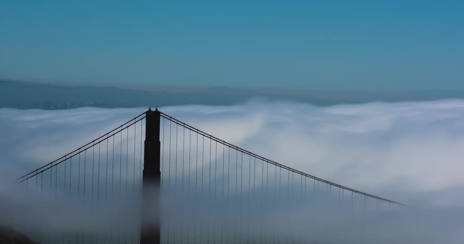 Clouds rolling over a tall bridge