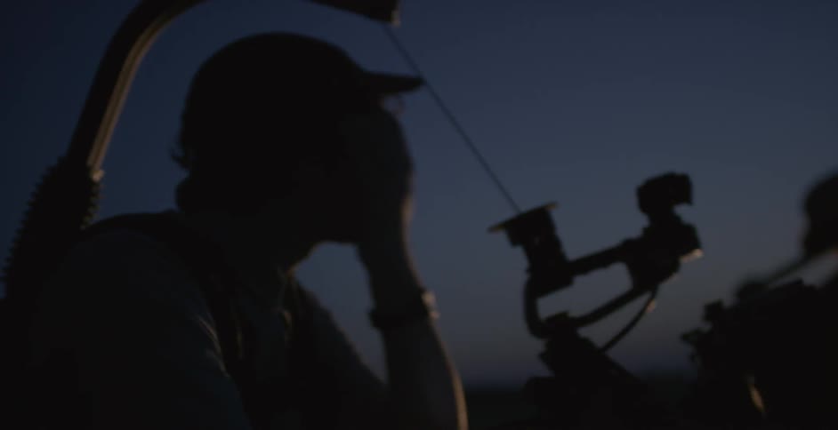 A group of people outside in the night filming