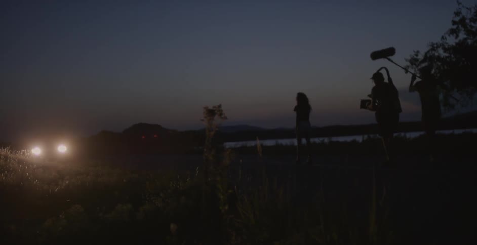 Group of people with recording equipment walking outside at night