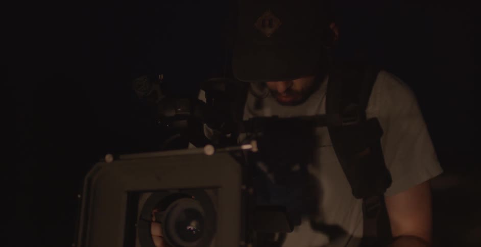 A man is operating a camera at night