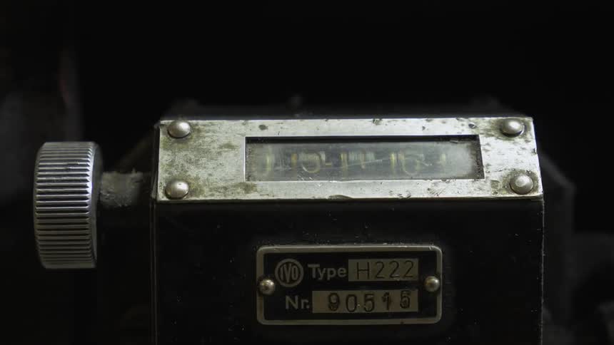 A close up view of a piece with numbers and a knob on it