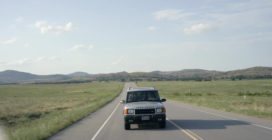 An suv drives along a country road