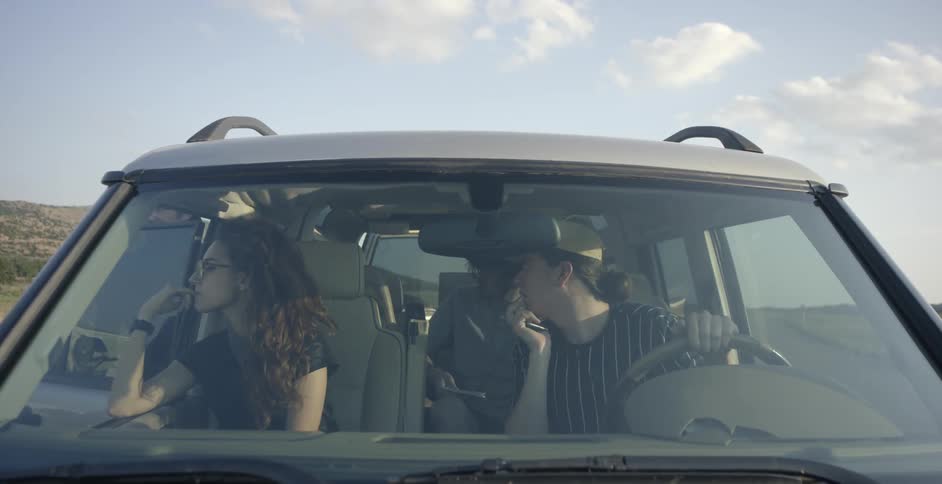 People wait for a man to get into a parked car