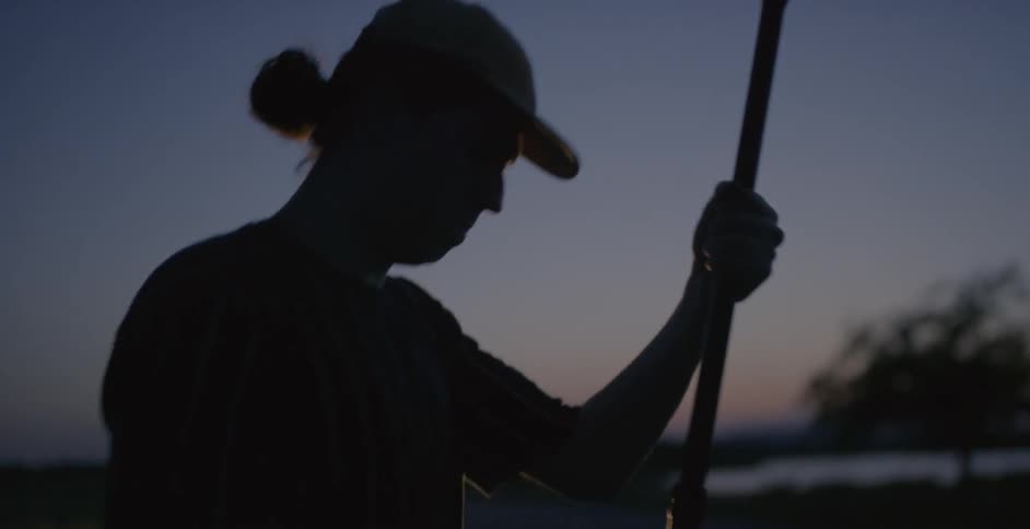 A man is raising a boom mic at dawn