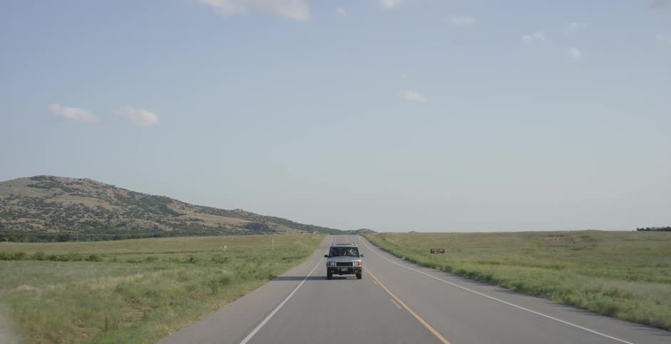 A truck is driving down an empty road