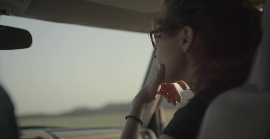 Wind blows a woman's hair inside a vehicle